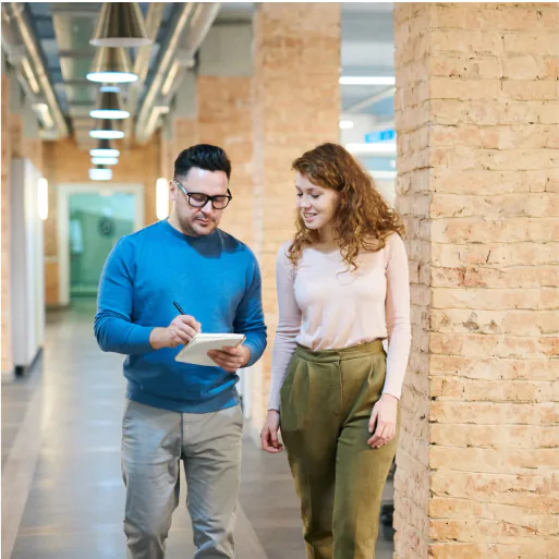 Business consultation with coach and client walking and taking notes.